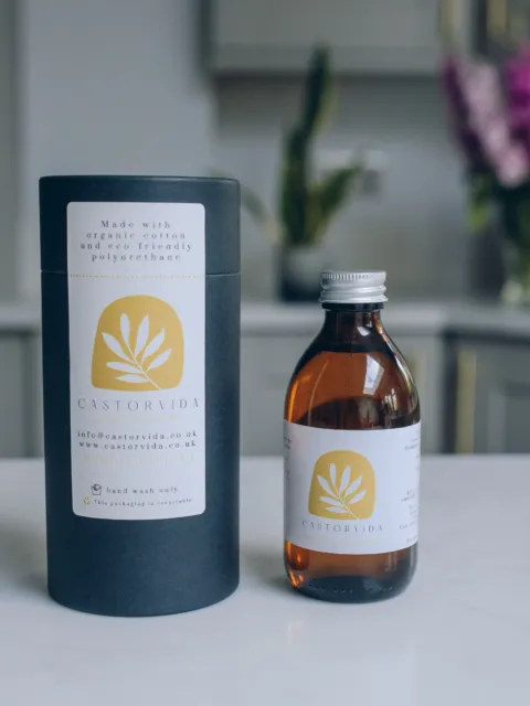 Castorvida bottle and packaging on a kitchen counter with flowers in the background.