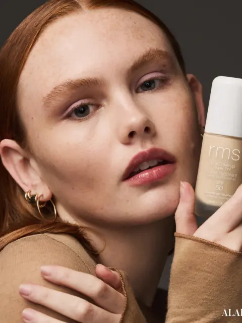 Person holding RMS Beauty foundation bottle, labelled "Alabaster".