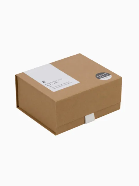 Brown cardboard gift box with white label and round black sticker.