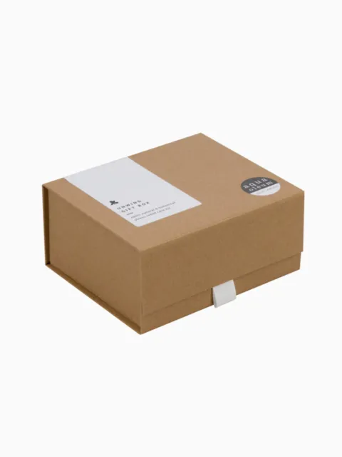 Brown cardboard gift box with white label and round sticker.