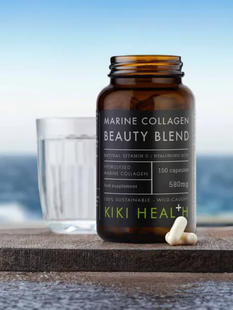 Marine Collagen Beauty Blend bottle with capsules, glass of water, ocean background.