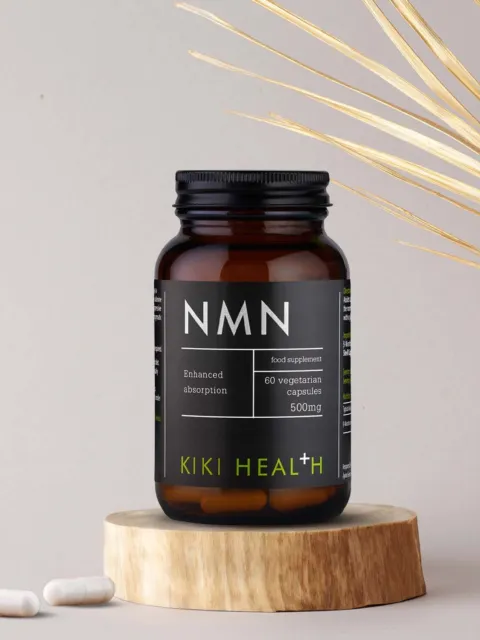 NMN supplement bottle with 60 vegetarian capsules, 500mg, on a wooden stand.