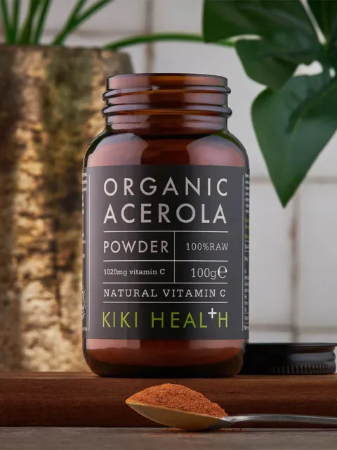 Brown jar of organic acerola powder, 100g, with a spoonful of powder in front.