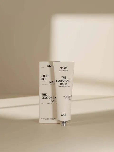 Deodorant balm tube and box with text, set against a neutral background.