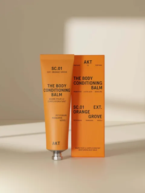 Orange tube and box of AKT Body Conditioning Balm, SC.01 Orange Grove.