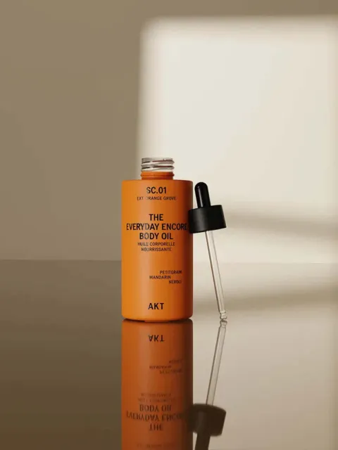 Orange bottle of body oil with dropper, labelled "The Everyday Encore Body Oil".