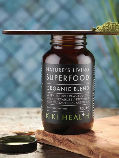 Brown bottle labelled "Nature's Living Superfood Organic Blend" with green powder on a spoon.