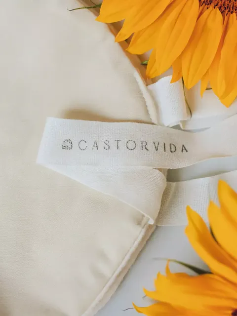 Cream fabric with "CASTORVIDA" label, surrounded by bright yellow sunflowers.