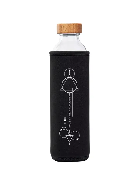 Glass bottle with wooden lid in black sleeve, geometric design, text: "Trust the Process".