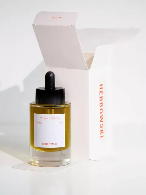 Glass bottle of Sylvan Sommer oil, 50ml, with dropper, beside open Herbowski box.