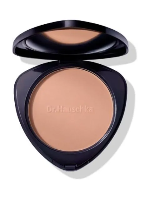 Compact powder with "Dr. Hauschka" embossed, in a black case with open lid.