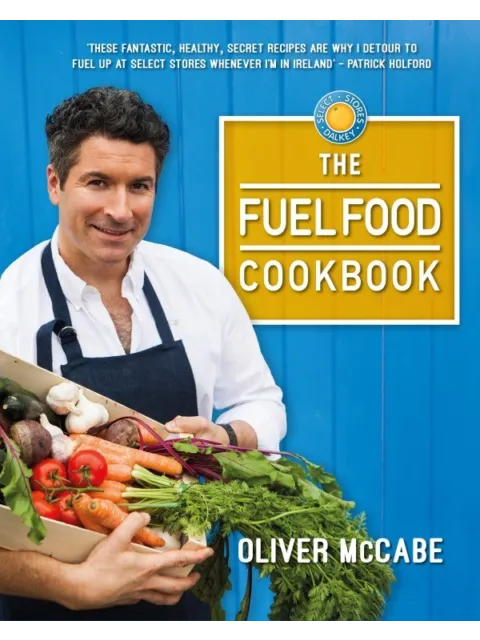 Man holding vegetables, wearing apron. "The Fuel Food Cookbook" by Oliver McCabe on blue background.