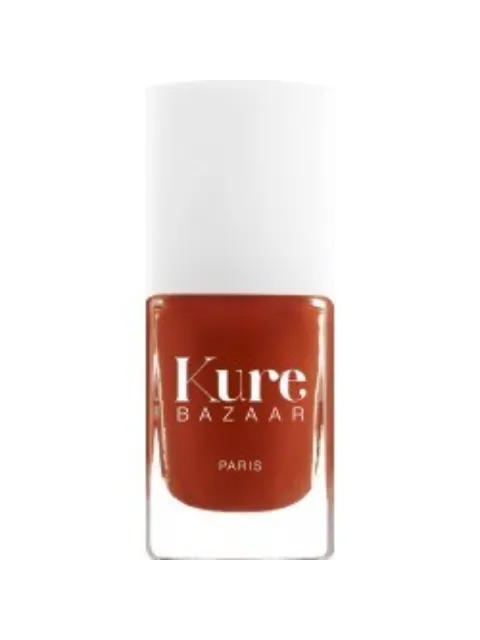 Kure Bazaar nail polish in a burnt orange shade, white cap, text reads "Kure Bazaar Paris".