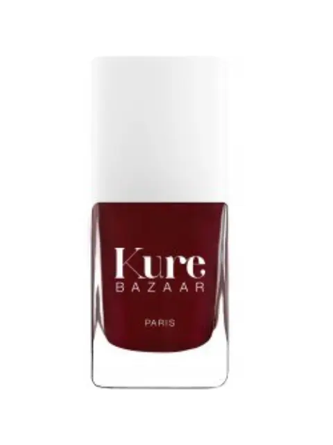 Kure Bazaar nail polish bottle, deep red colour, white cap, text "Kure Bazaar Paris".