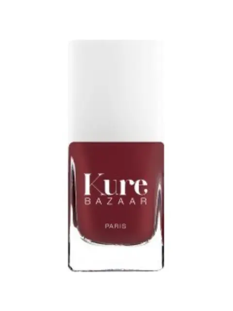 Kure Bazaar nail polish bottle, deep red colour, white cap, text "Kure Bazaar Paris".