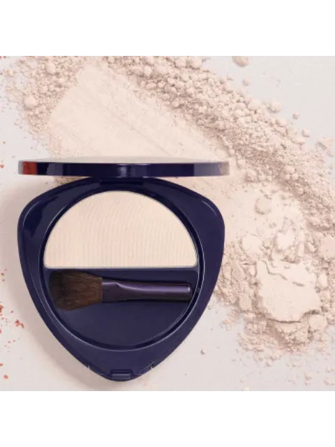 Compact with white powder and brush, surrounded by loose powder.