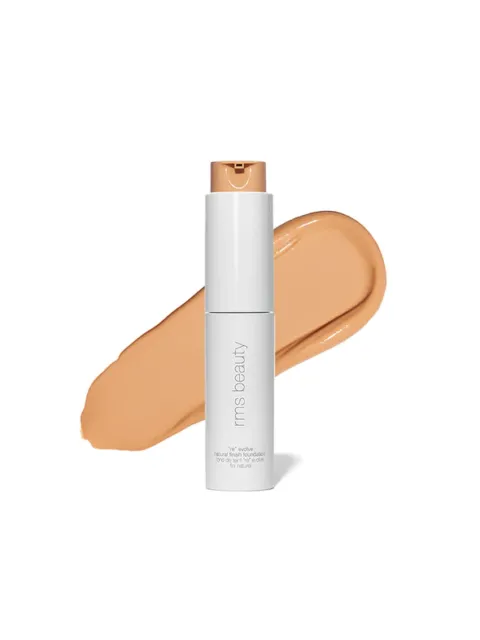White bottle of RMS Beauty foundation with beige swatch behind.