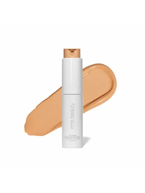 White bottle of RMS Beauty foundation with beige swatch behind.