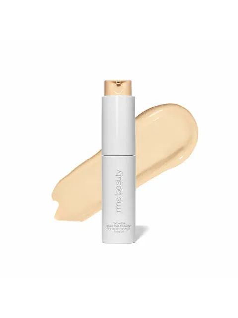 White bottle of RMS Beauty foundation with beige swatch behind.