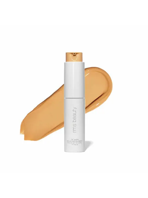 White bottle of RMS Beauty foundation with beige swatch behind.