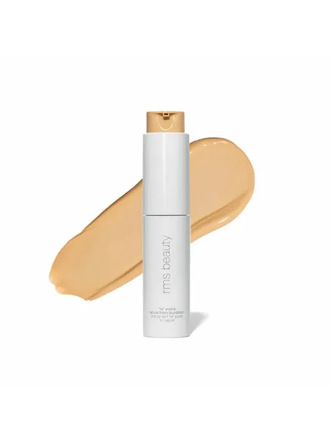 White bottle of RMS Beauty foundation with beige swatch behind.