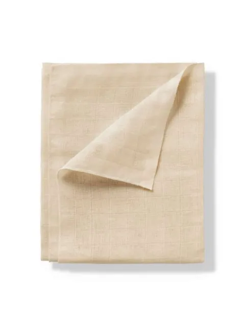 Beige linen cloth folded with a corner turned up.
