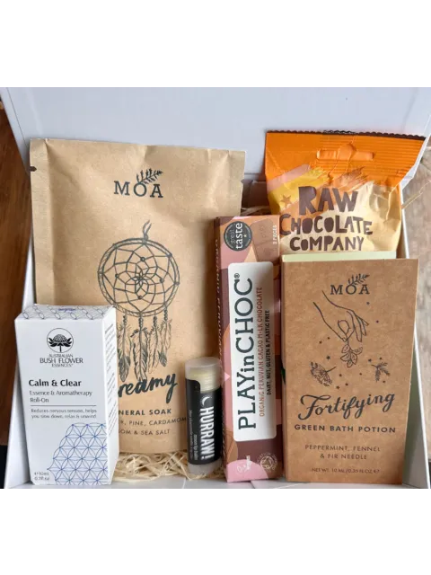 Wellness gift box with MOA bath products, chocolate, lip balm, and aromatherapy roll-on.