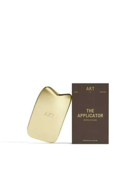Gold AKT applicator with packaging labelled "The Applicator".
