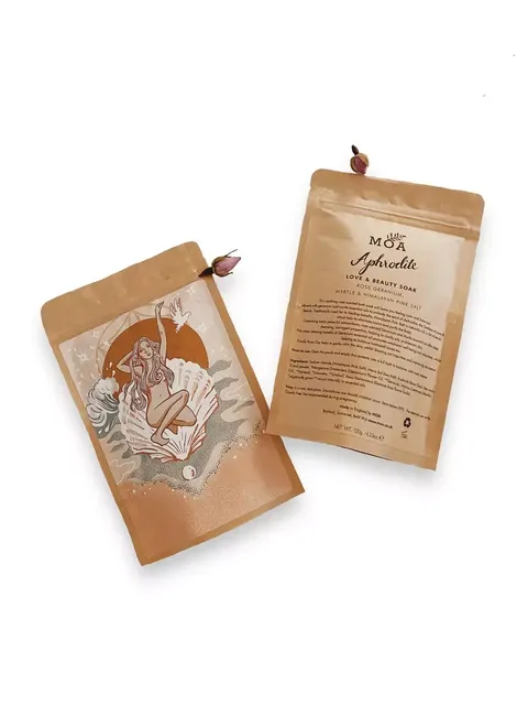 Two brown pouches of MOA Aphrodite Love & Beauty Soak with floral design and text.