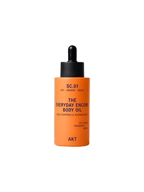 Orange bottle of AKT Everyday Encore Body Oil with dropper lid.