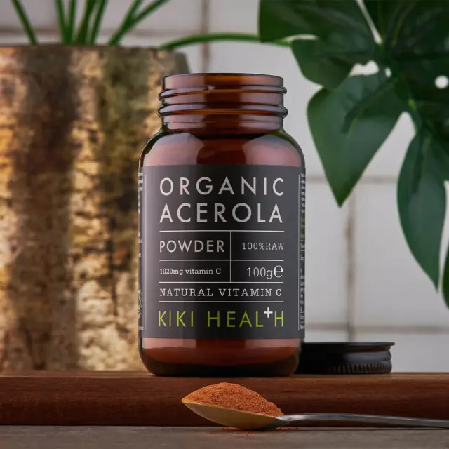 Brown jar of organic acerola powder, 100g, with a spoonful of powder in front.