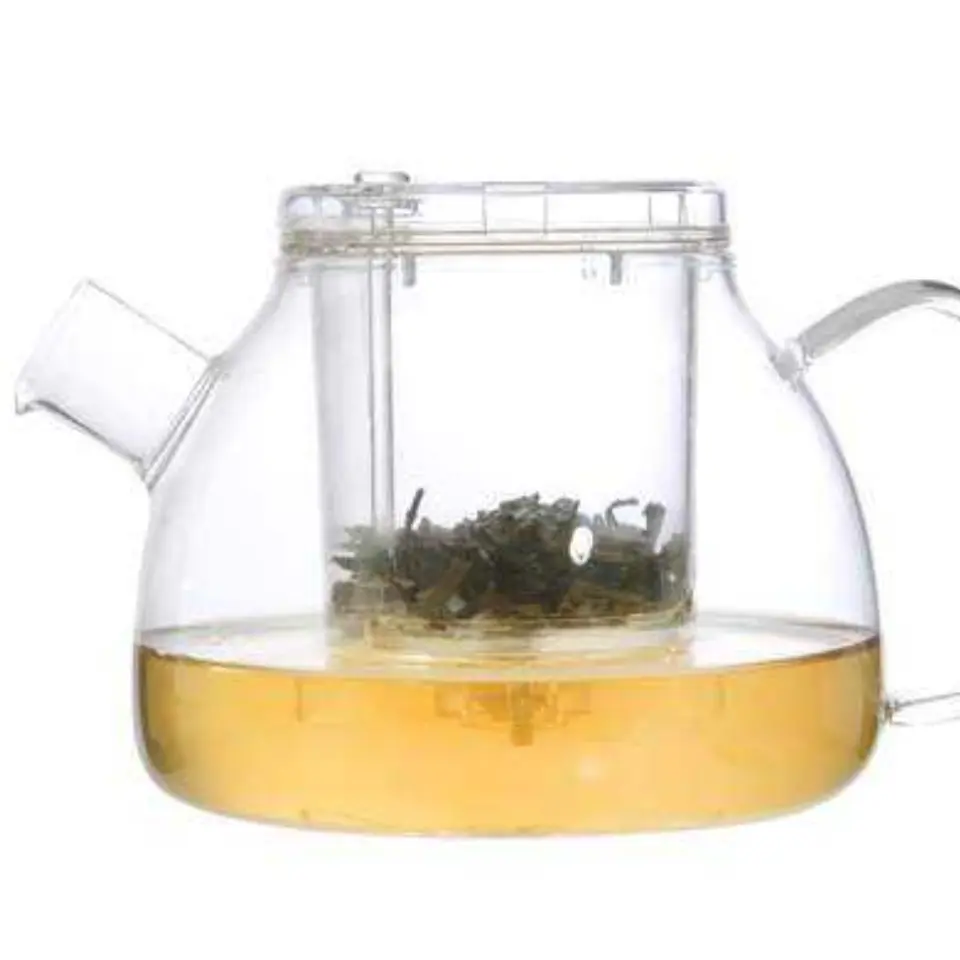 Clear glass teapot with infuser, containing green tea leaves and brewed tea.