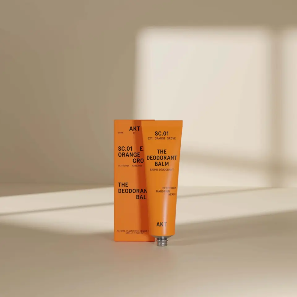 Orange deodorant balm tube and box with text "SC.01 EXT. ORANGE GROVE".