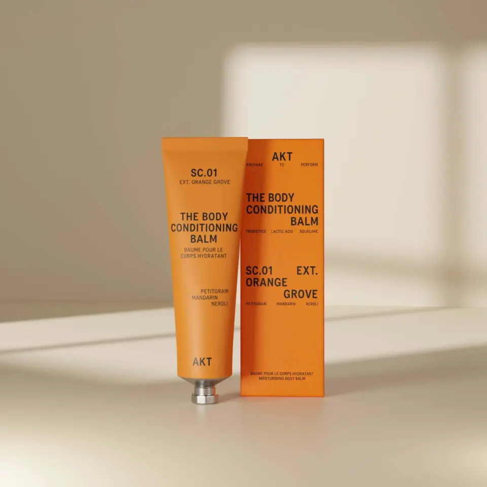 Orange tube and box of AKT Body Conditioning Balm, SC.01 Orange Grove.