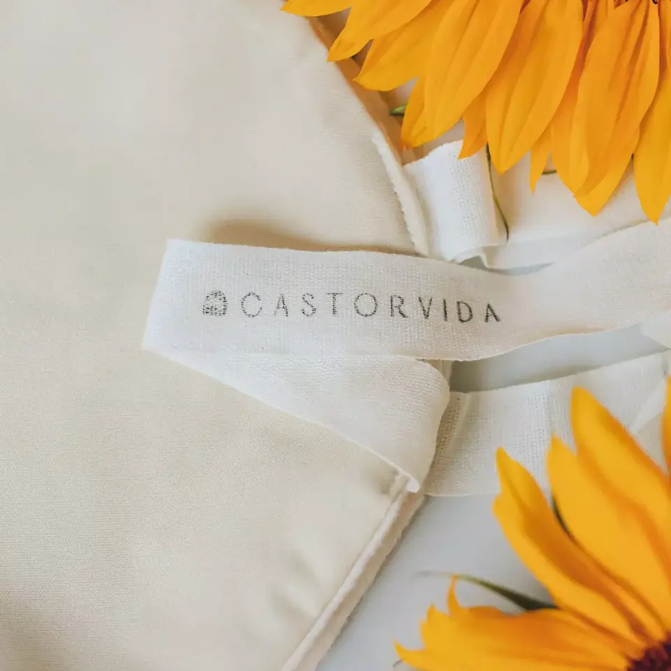Cream fabric with "CASTORVIDA" label, surrounded by bright yellow sunflowers.