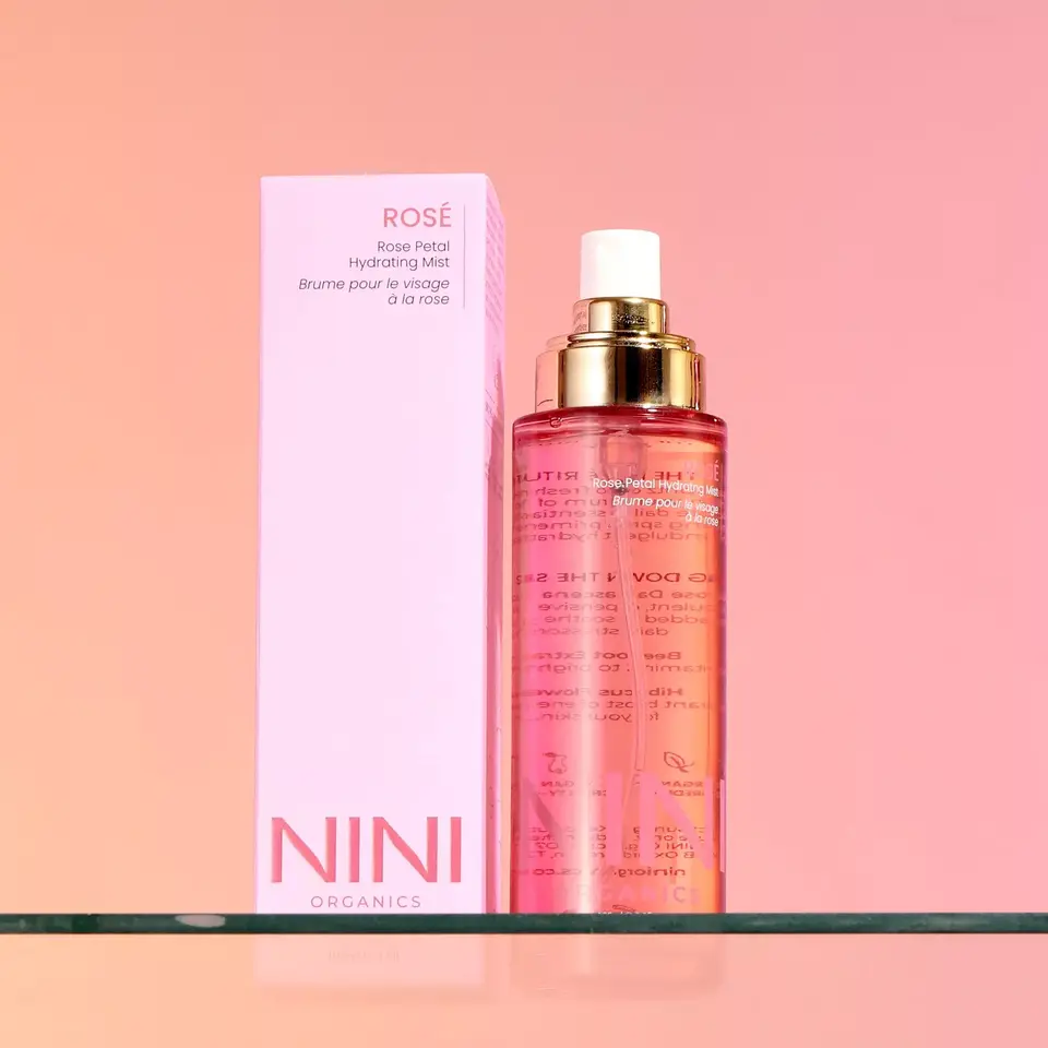 NINI Organics Rosé Hydrating Mist with pink box on glass shelf.