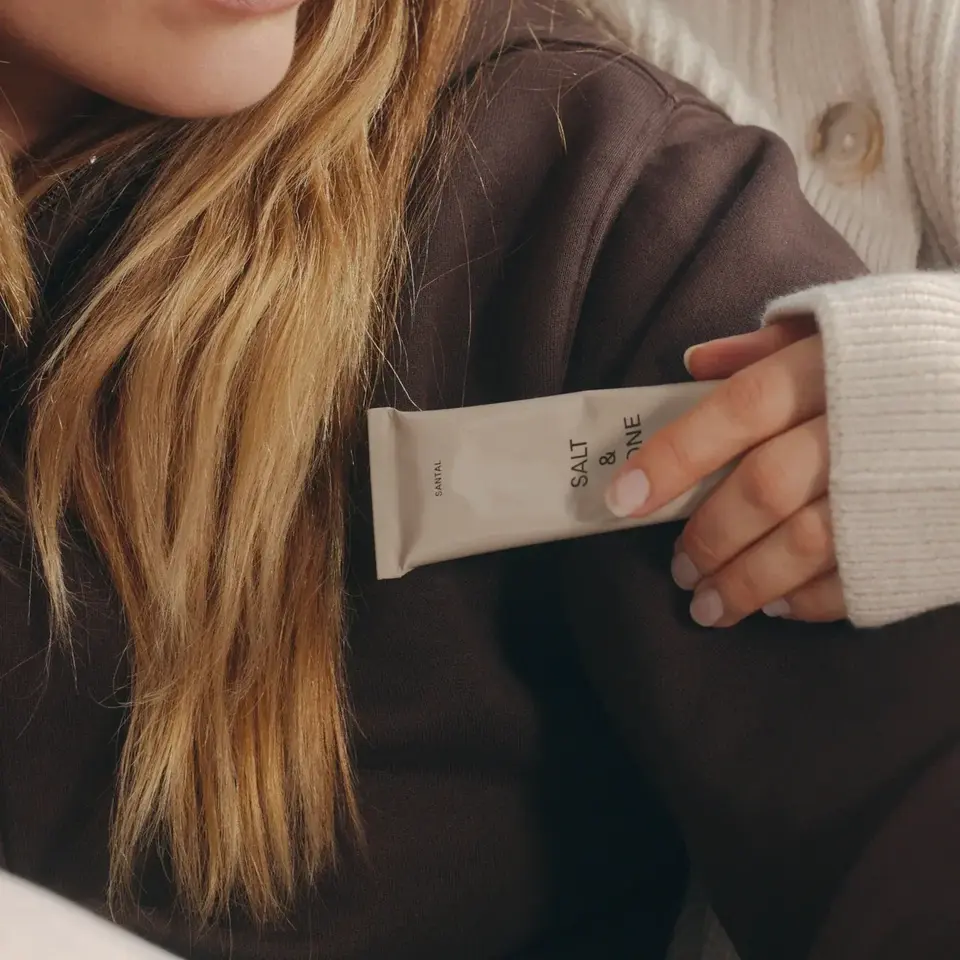 Person holding a tube labelled "Salt & Vine" against a brown jumper.
