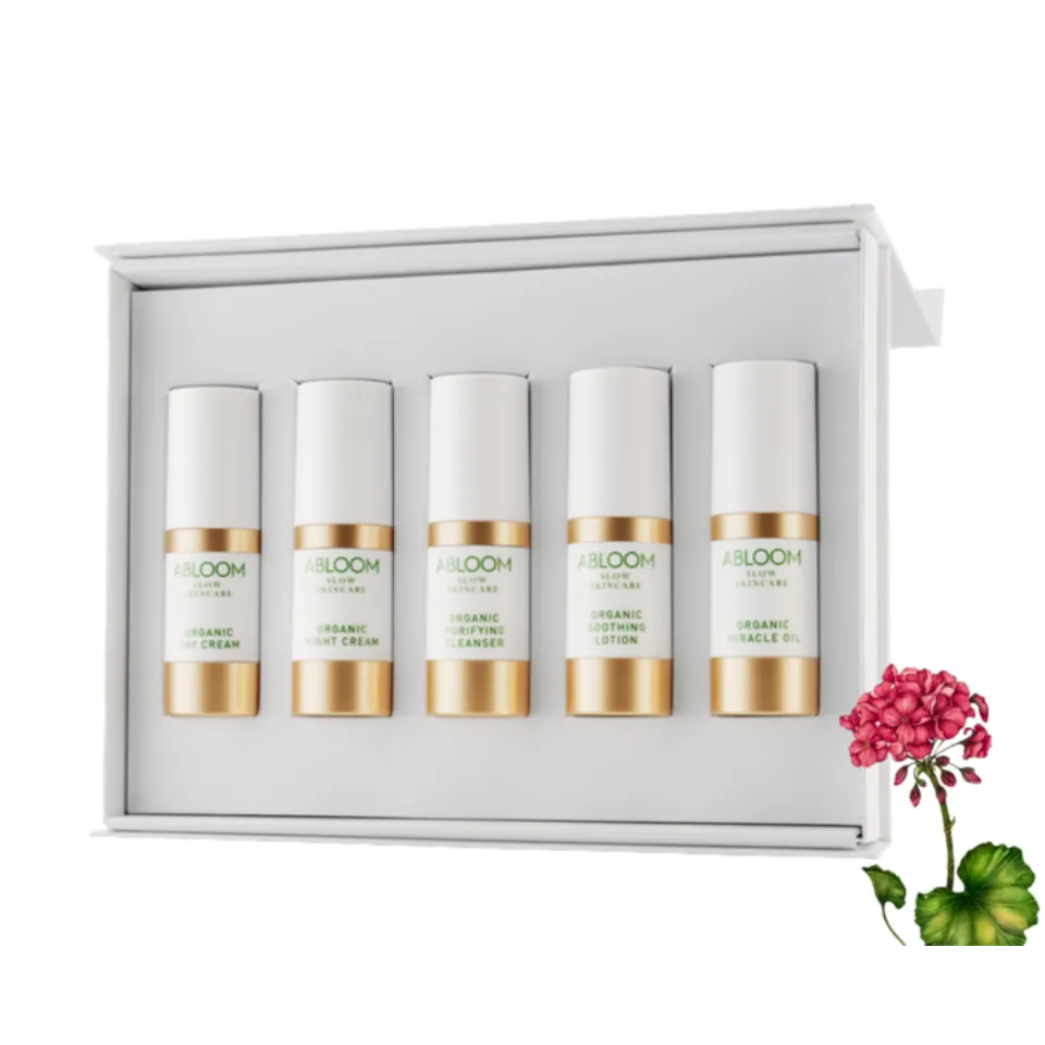 Five Abloom skincare bottles in a white box, with a pink flower on the side.