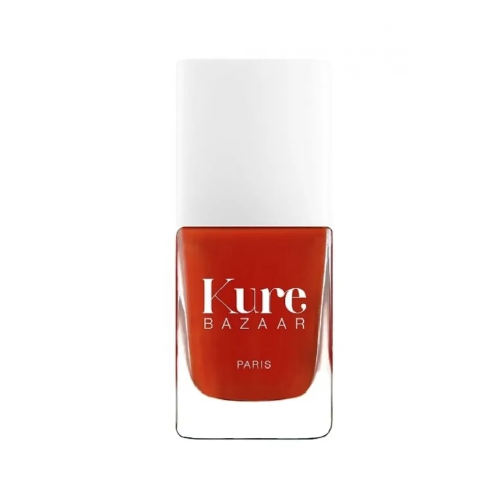 Kure Bazaar nail polish bottle with red-orange colour and white cap.