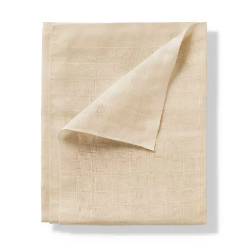 Beige linen cloth folded with a corner turned up.