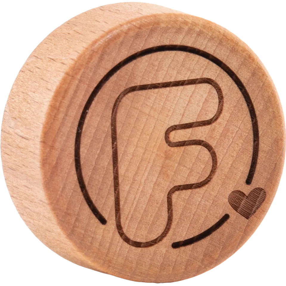 Round wooden lid with engraved letter "F" and heart symbol.