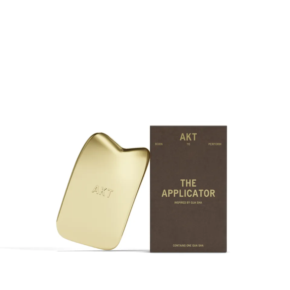 Gold AKT applicator with packaging labelled "The Applicator".