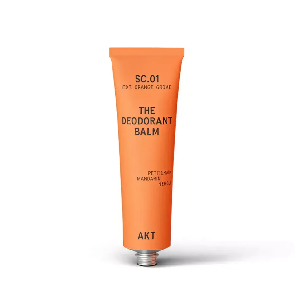Orange tube of deodorant balm with text: SC.01, Orange Grove, Petitgrain, Mandarin, Neroli, AKT.