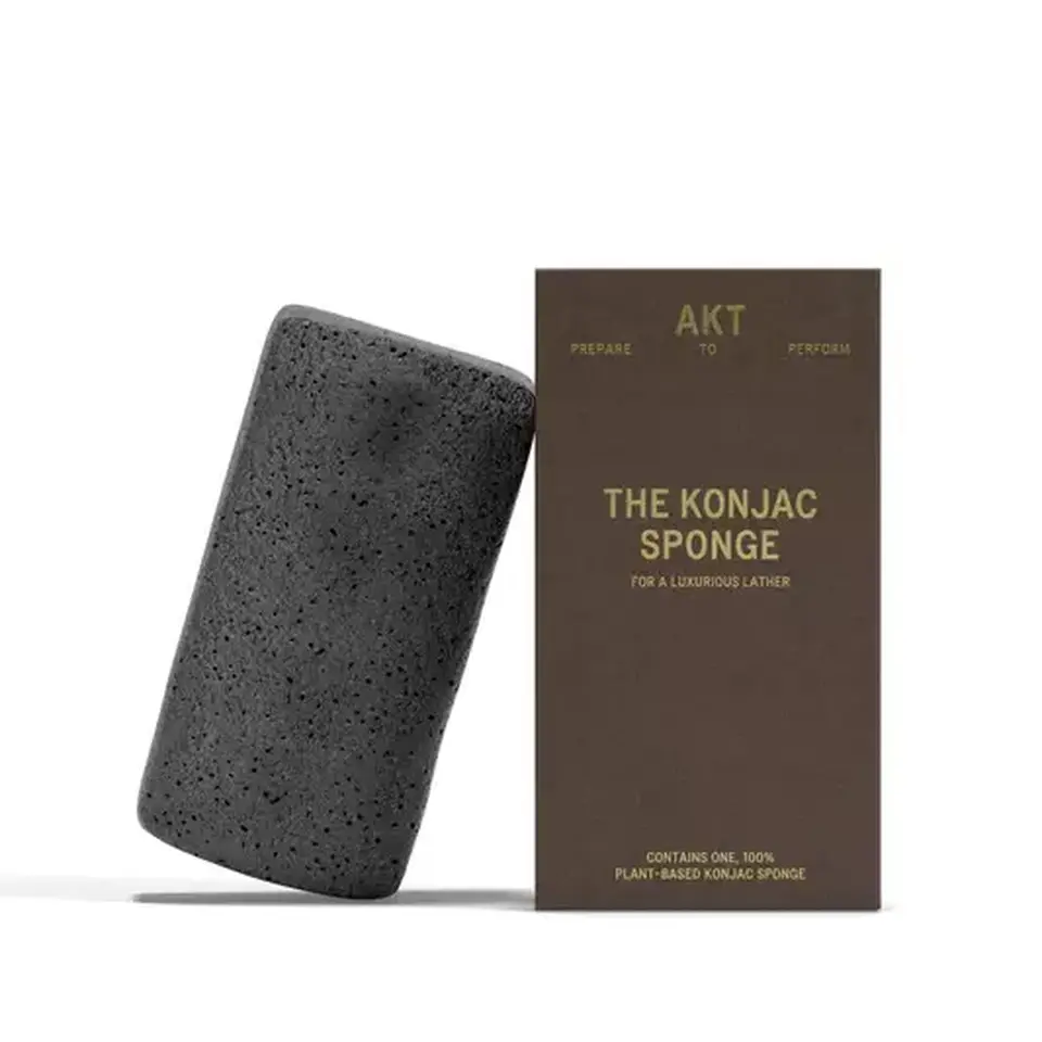 Black konjac sponge next to brown box labelled "The Konjac Sponge".