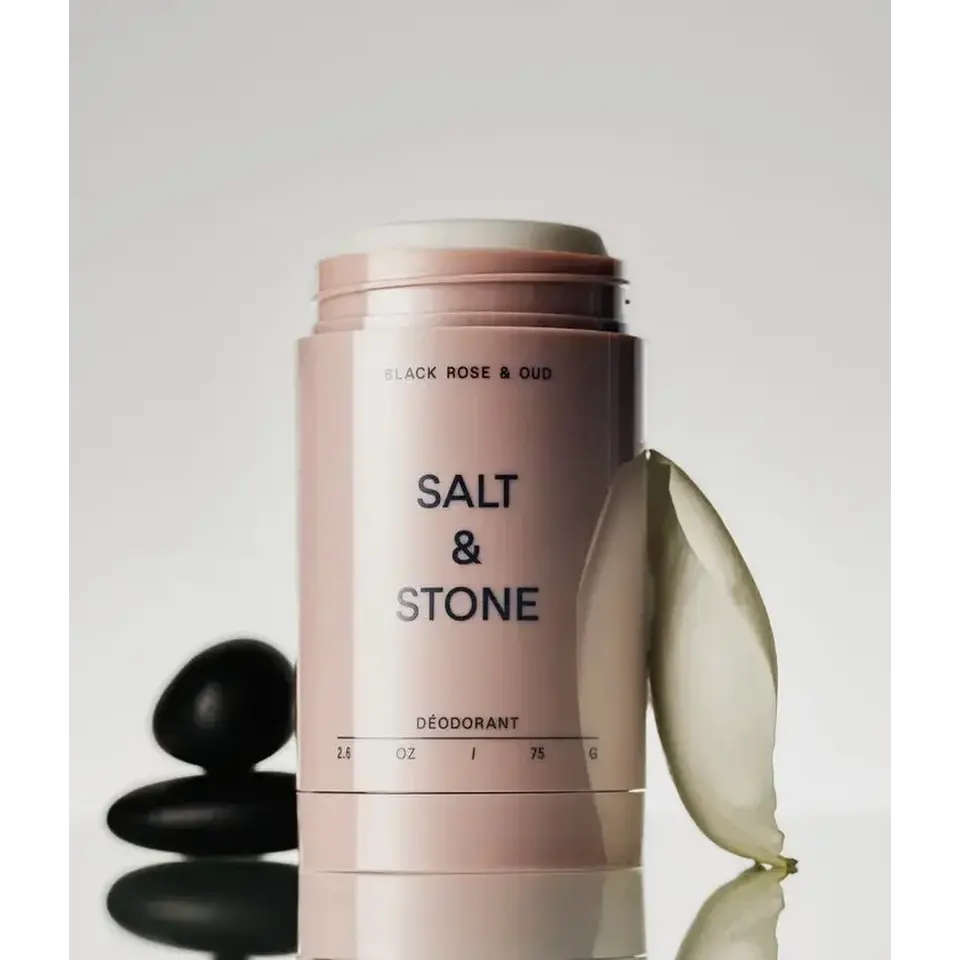 Salt & Stone deodorant with black stones and a white petal.