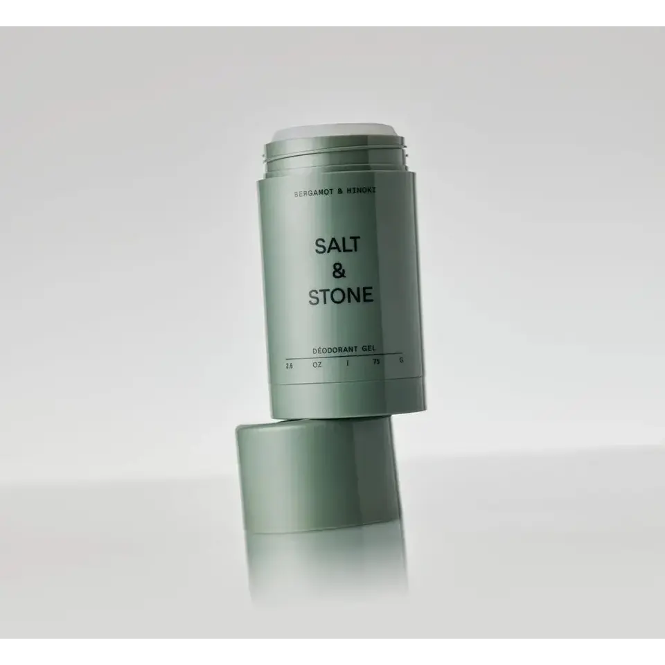 Salt & Stone deodorant gel in a green container, open with cap on the side.