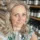Woman with blonde hair in a shop with shelves of skincare products.