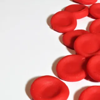 Red clay discs scattered on a white surface.