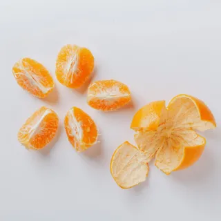 Peeled orange with segments on a white background.