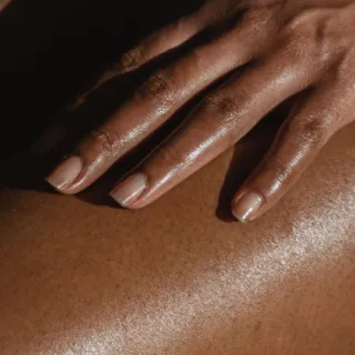 Hand with manicured nails on moisturised skin.